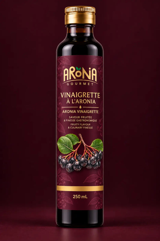 Bouteille en verre foncé avec bouchon doré et étiquette bordeaux illustrant des baies d’aronia vinaigrette gourmet